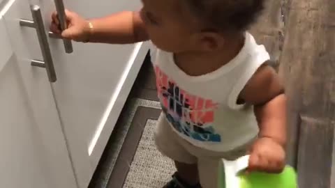 Frustrated Toddler Tries to Open Cabinet