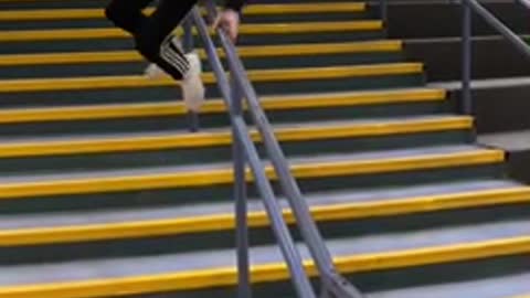 Boy slides down staircase hand rail and falls backwards