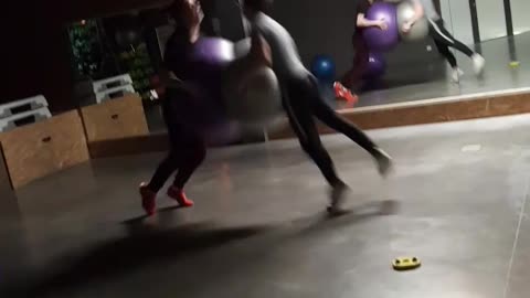 Two guys run at each other with exercise ball, faces smash into each other