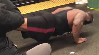 Man black red shorts push ups on subway floor