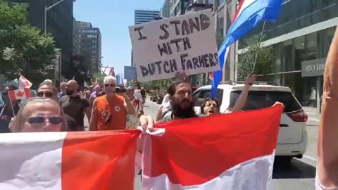 Canadians in Toronto holding flags from the Netherlands stand in solidarity with the #DutchFarmers