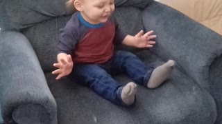 Excited toddler rocks in grown up chair