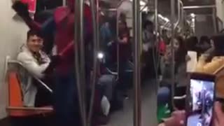 Chubby spiderman on subway train dances spanish music