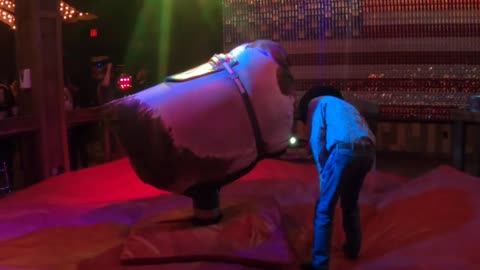 Mechanical bull riding in Las Vegas: The bull is inspected by its controller as the night begins