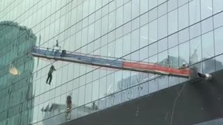 Window-washing scaffolding swings free