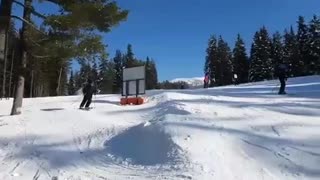 Guy in all black tries to do ski jump spin and front of ski clips floor and he fails