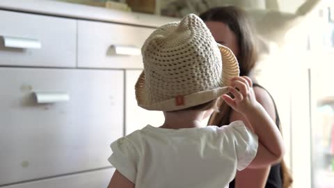 Toddler putting on a hat