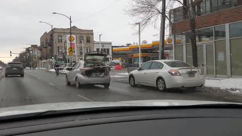 Subcompact Car Driving With Long Wooden Boards Sticking Far Out