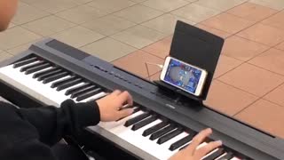 Kid playing piano while playing game on phone