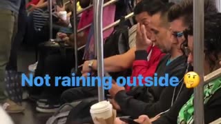 Person on subway standing near door with grey umbrella open