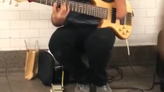 Man with one hand blue shirt playing guitar