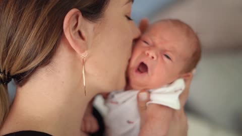 Mother Kissing her Crying Baby