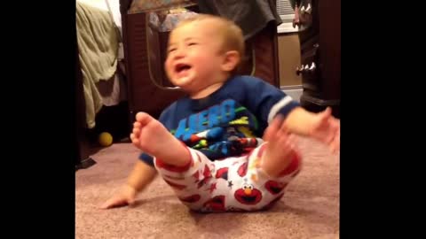 Laughing baby falls over from excitement