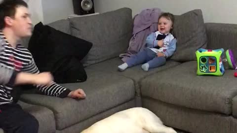 A baby boy is teasing a dad with the phone