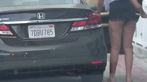 Two girls put surfboard in back seat