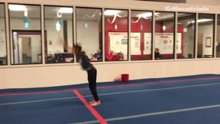Kid boy gymnastics does flip on blue mat falls on back