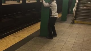 Guy hat backwards face between green pillar subway