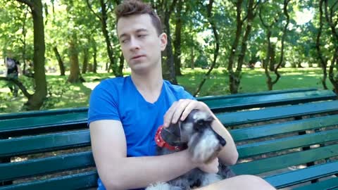 Happy boy cuddling his dog and speaking to the camera in the park, steadycam sho