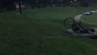 Guy rides bike down a hill and ends up falling