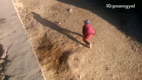 Boy in red jacket jumps off ledge lands on butt