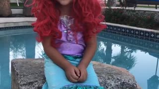 Little girl playing dress up and singing