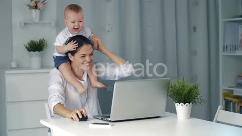 Mother with Baby Working on Laptop at Home