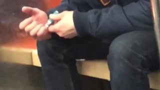 Man clipping nails beanie blue jacket