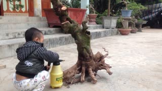 cute baby-boy watering plants