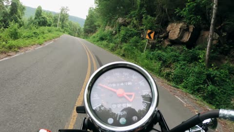Speedometer of a Motorcycle on a Scenic Road