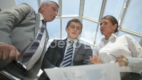 Bottom View Of Two Men And Business Woman Talking About A Project Looking At The Tablet