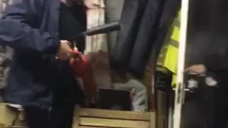 Man in blue uses fire extinguisher on man who walks in