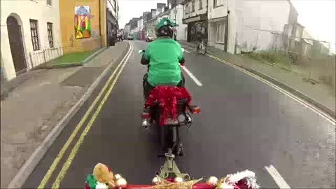 Santa arrives on motorcycle towed sleigh