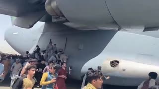 People hanging on to plane at Kabul airport.