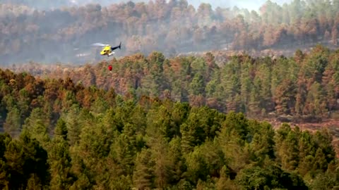 Firefighters drop water over wildfires in Spain