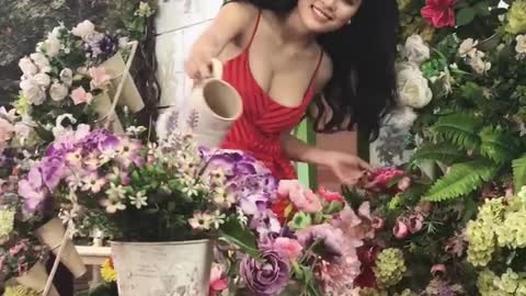 Beauty girl is watering the flowers
