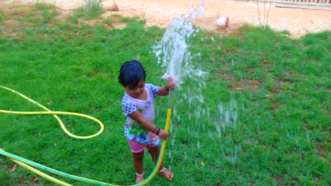 Listen To The Water - Little girl playing with water at garden