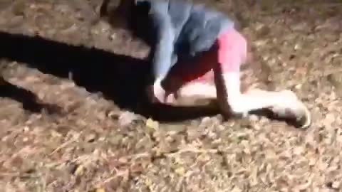 Guy red shorts rope swings falls on back