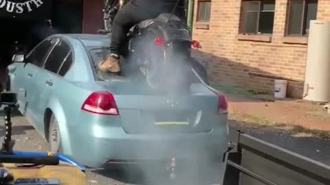 Biker Does Burnout on Back of Car