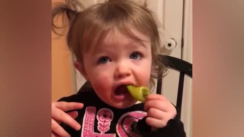 The baby girl eat green pepper see her reaction