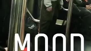 Guy in grey jacket dances and sways on subway