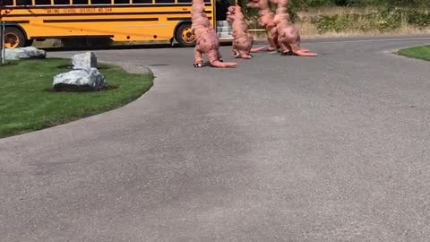 Family Of Dinosaurs Is Waiting For A Girl To Get Off The School Bus