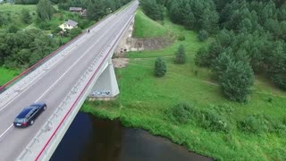 Flying drone over the bridge over the river