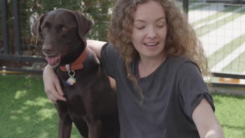 A Woman Petting Her Dogs Outdoors