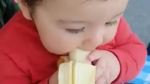 Very cute baby eating banana