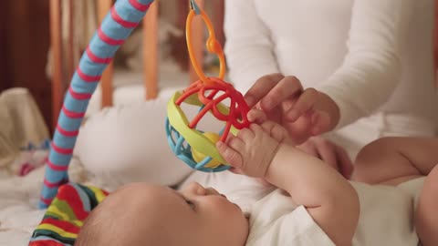 Newborn baby plays with a toy