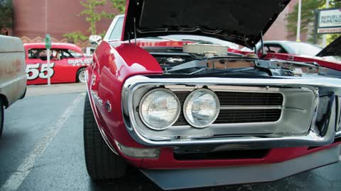 Close-up Of The Front End Of A Parked Classic Car With Its Engine Showing From The Open Hood