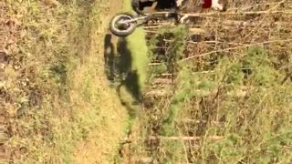 Red shirt guy tries to jump motorcycle dirt ramp and falls in grass