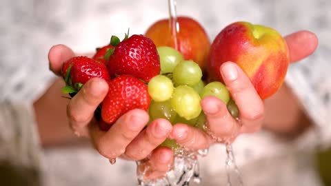 Rinsing strawberries, apples and grapes holding hands What is the fourth fruit carefully consider