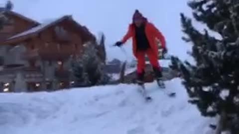 Guy skis off snow onto concrete parking lot and falls