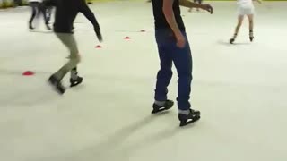 Guy in black shirt and black hat rollerblading loses balance and falls backwards